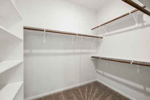 a view of walk in closet with empty racks