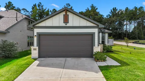 a front view of a house with a yard and potted plants