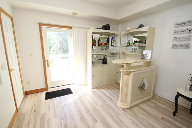 a view of a kitchen with fridge and wooden floor