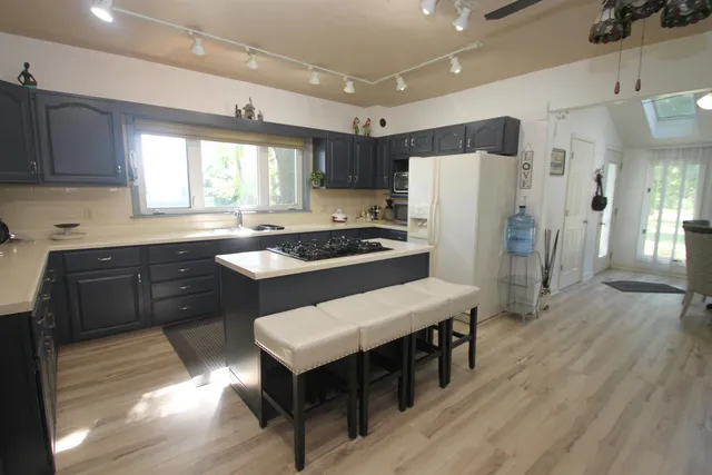 a kitchen with a table chairs refrigerator and window