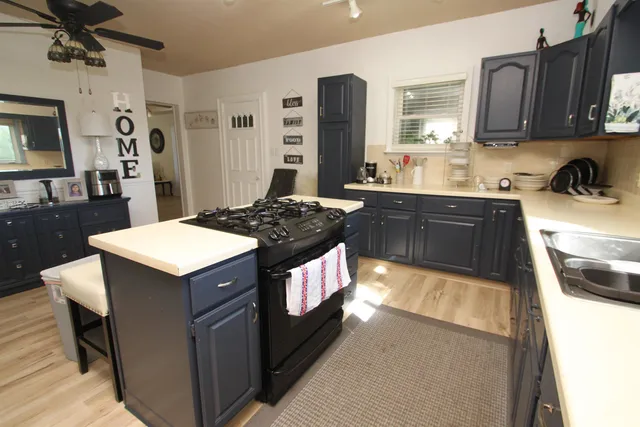 a kitchen with a stove a sink a refrigerator and cabinets