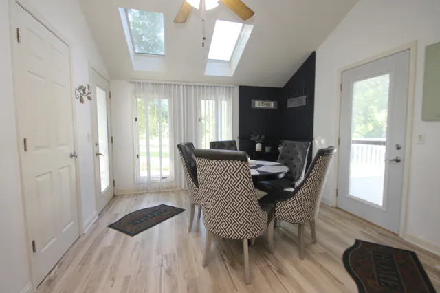 a view of a a dining room with furniture window and wooden floor