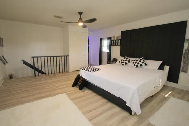 a spacious bedroom with a bed and a flat screen tv