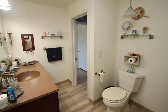 a bathroom with a granite countertop toilet sink and mirror