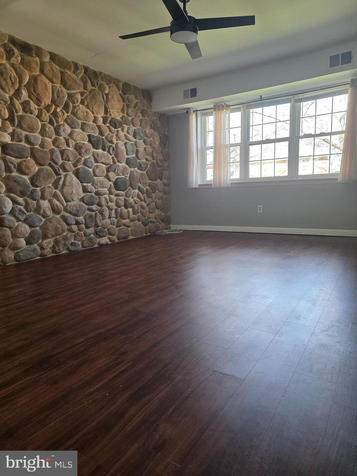 806 South Avenue, Unit E9 Secane, PA 19018 - Photo 8 of 17 an empty room with wooden floor and windows