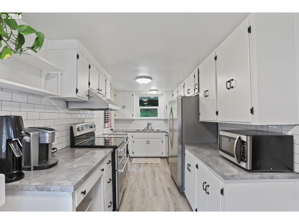 32997 Sykes Road St. Helens, OR 97051 - Photo 12 of 44 a kitchen with stainless steel appliances kitchen island granite countertop a refrigerator and microwave