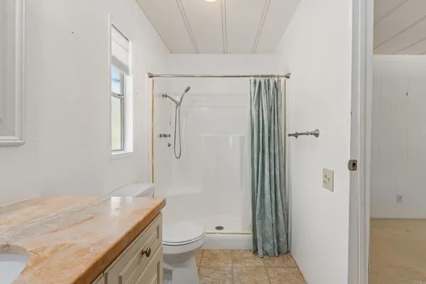 a bathroom with a granite countertop sink toilet and shower