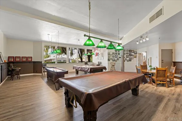 a kitchen with stainless steel appliances granite countertop a stove a sink dishwasher and a refrigerator with wooden floor