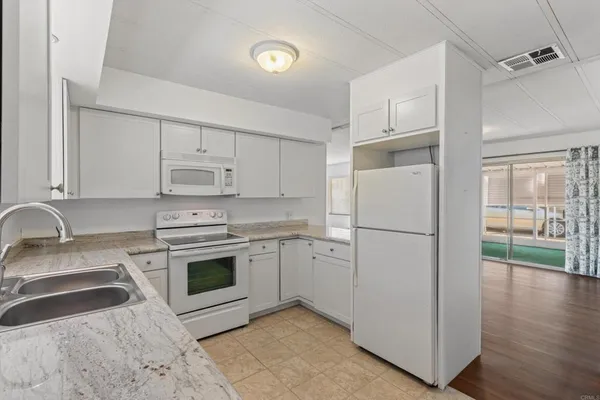 a kitchen with white cabinets and white appliances