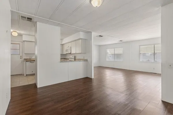 a view of a kitchen with wooden floors and refrigerator