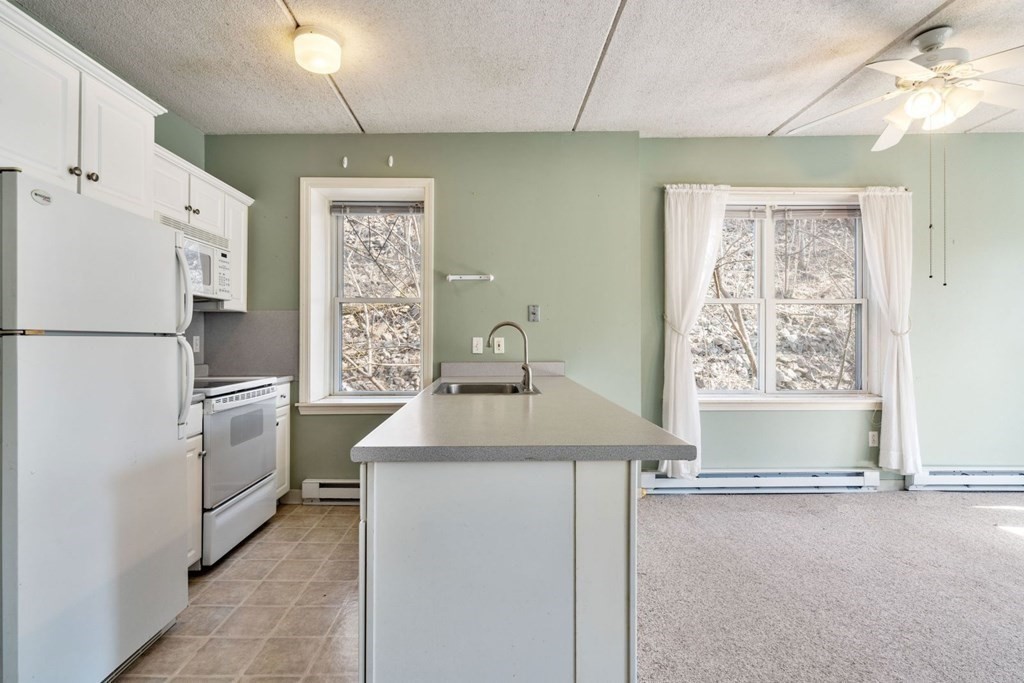 5 B Eileen Circle, Unit 11 Boston, MA 02130 - Photo 5 of 19 a kitchen with white cabinets and white appliances