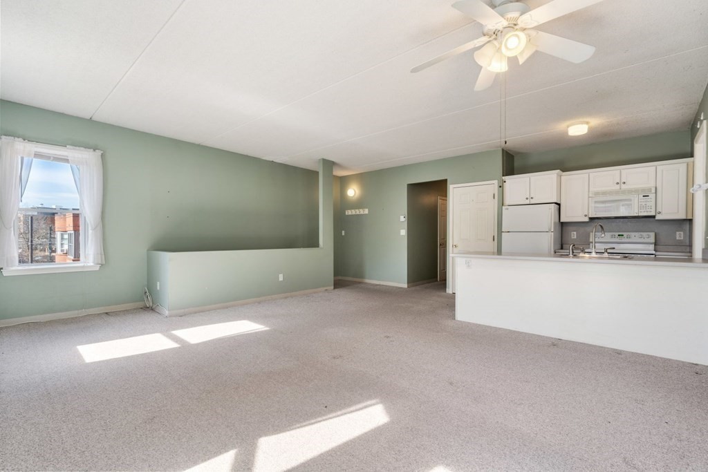 5 B Eileen Circle, Unit 11 Boston, MA 02130 - Photo 8 of 19 a view of an empty room with kitchen and window