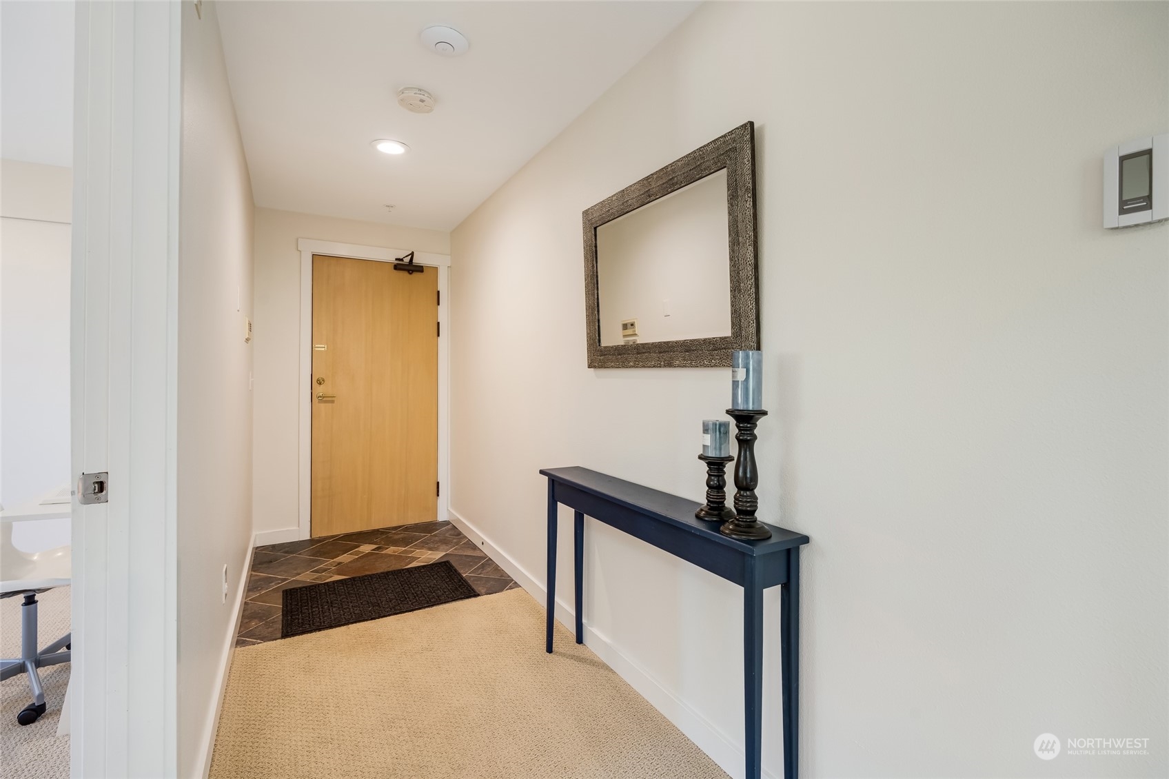 1110 West Howe Street, Unit 304 Seattle, WA 98119 - Photo 2 of 24 a hallway with mirror and a wooden floor