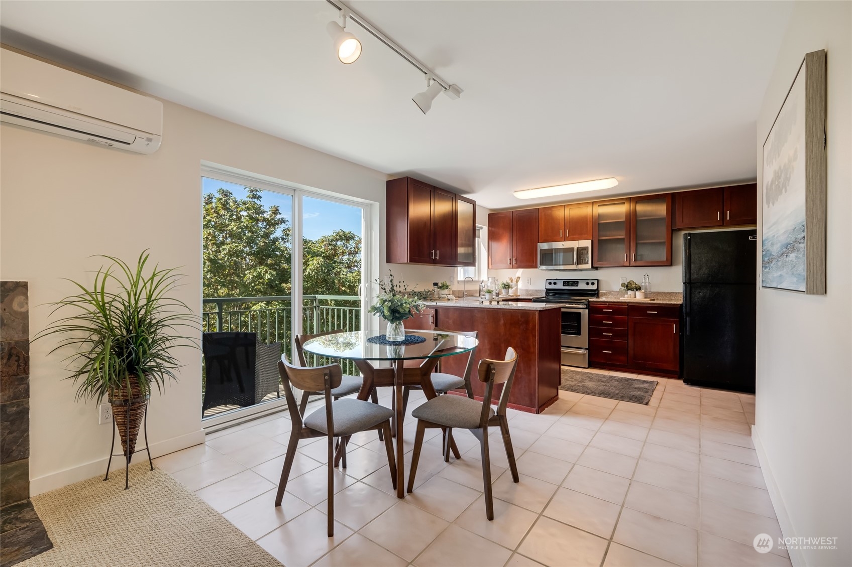 1110 West Howe Street, Unit 304 Seattle, WA 98119 - Photo 5 of 24 a kitchen with stainless steel appliances kitchen island granite countertop a refrigerator a stove a sink dishwasher and a dining table with garden view