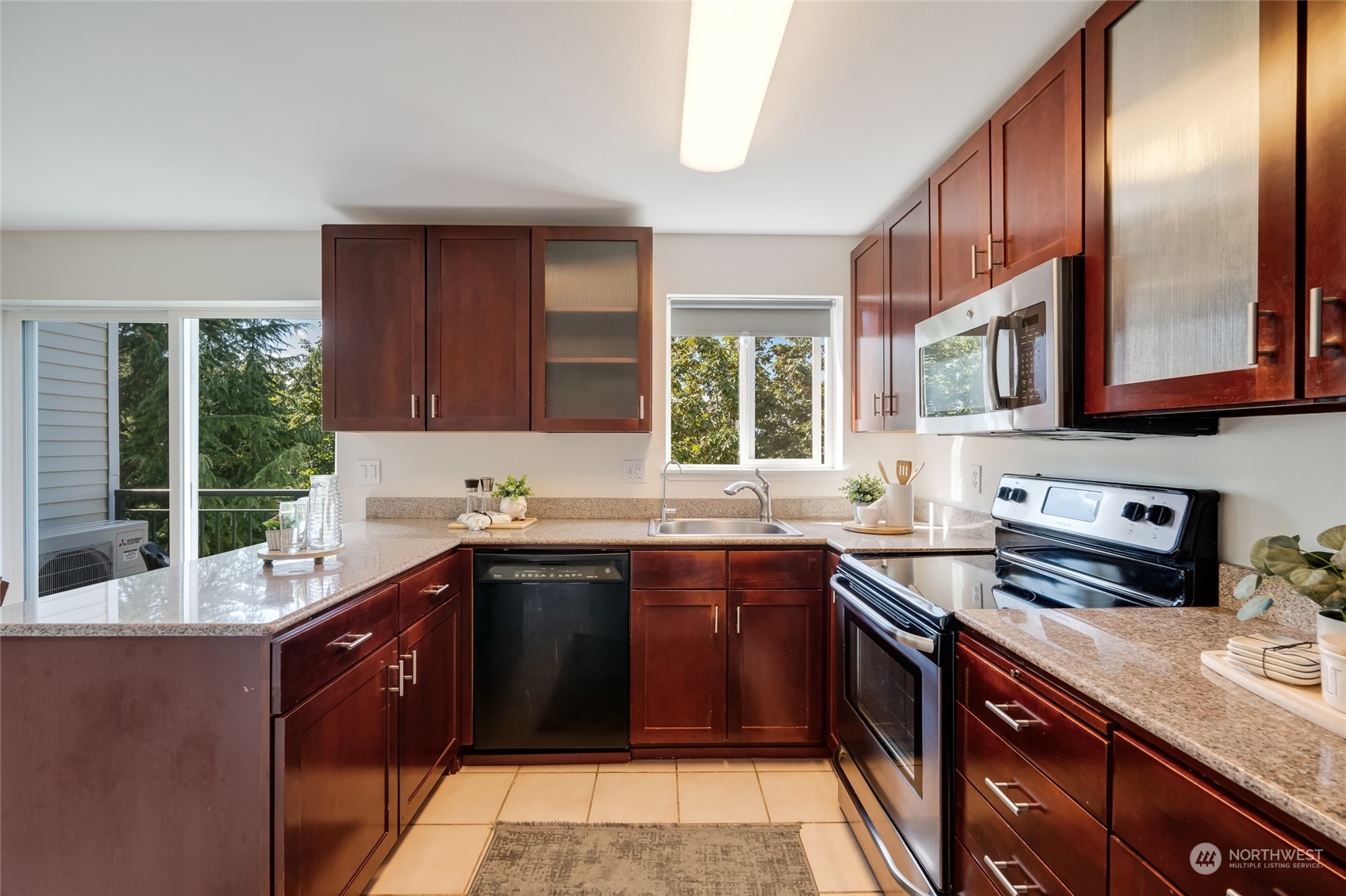 1110 West Howe Street, Unit 304 Seattle, WA 98119 - Photo 7 of 24 a kitchen with stainless steel appliances granite countertop a sink stove and cabinets