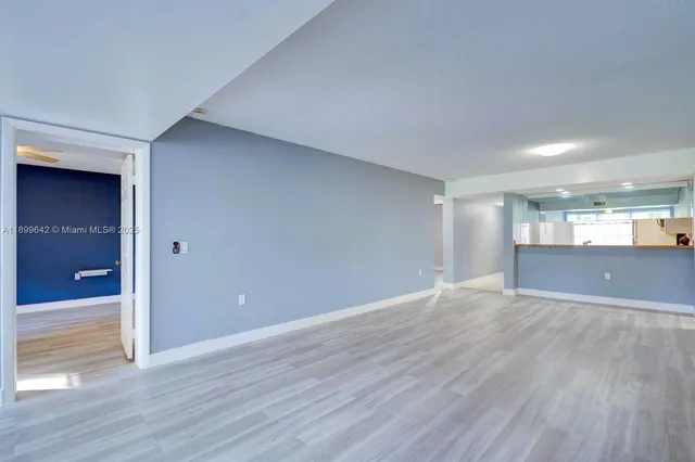 a view of an empty room with wooden floor