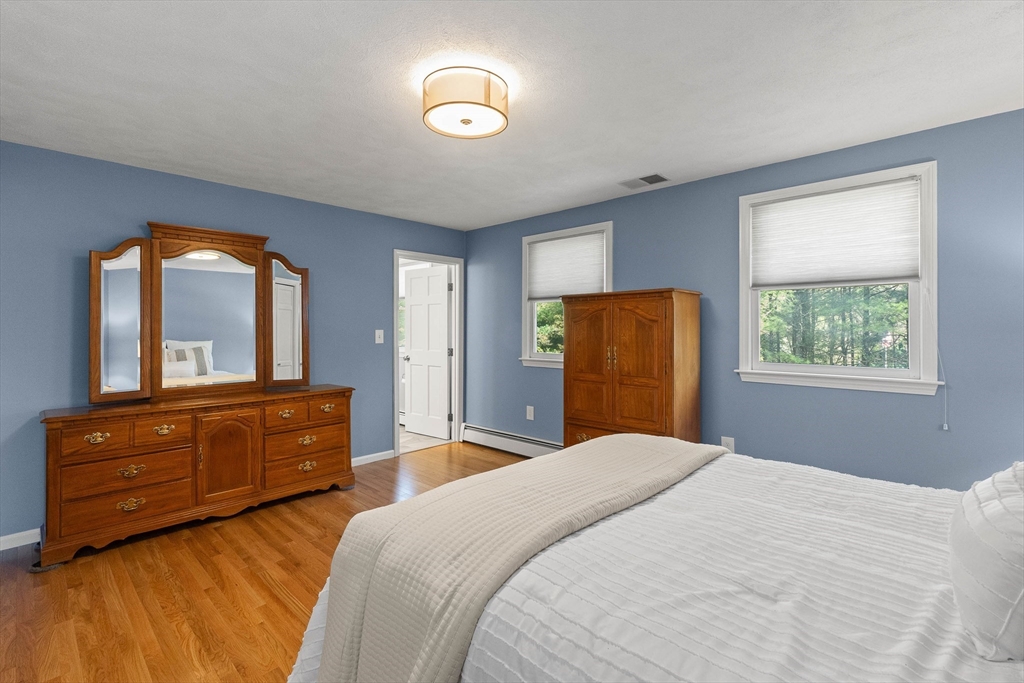 336 Sharpners Pond Road North Andover, MA 01845 - Photo 19 of 42 a bedroom with a bed and a dresser with mirror
