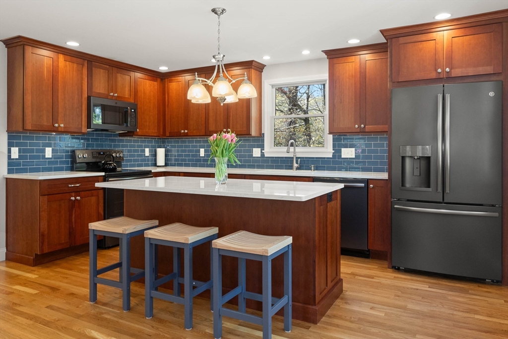 336 Sharpners Pond Road North Andover, MA 01845 - Photo 8 of 42 a kitchen with stainless steel appliances granite countertop a table chairs refrigerator and sink