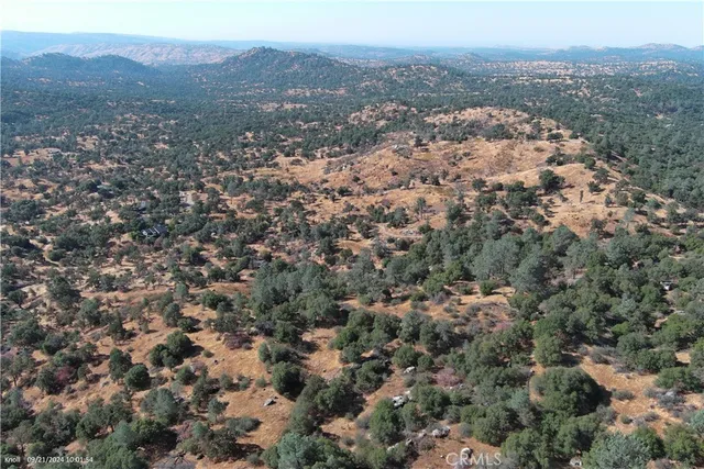 an aerial view of house with yard and mountain view in back