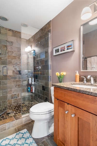 2002 West Barry Avenue Chicago, IL 60618 - Photo 15 of 25 a bathroom with a granite countertop toilet sink and shower