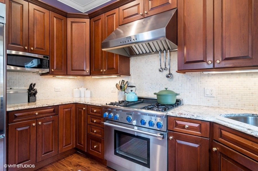 2002 West Barry Avenue Chicago, IL 60618 - Photo 4 of 25 a kitchen with stainless steel appliances granite countertop a sink a stove and cabinets