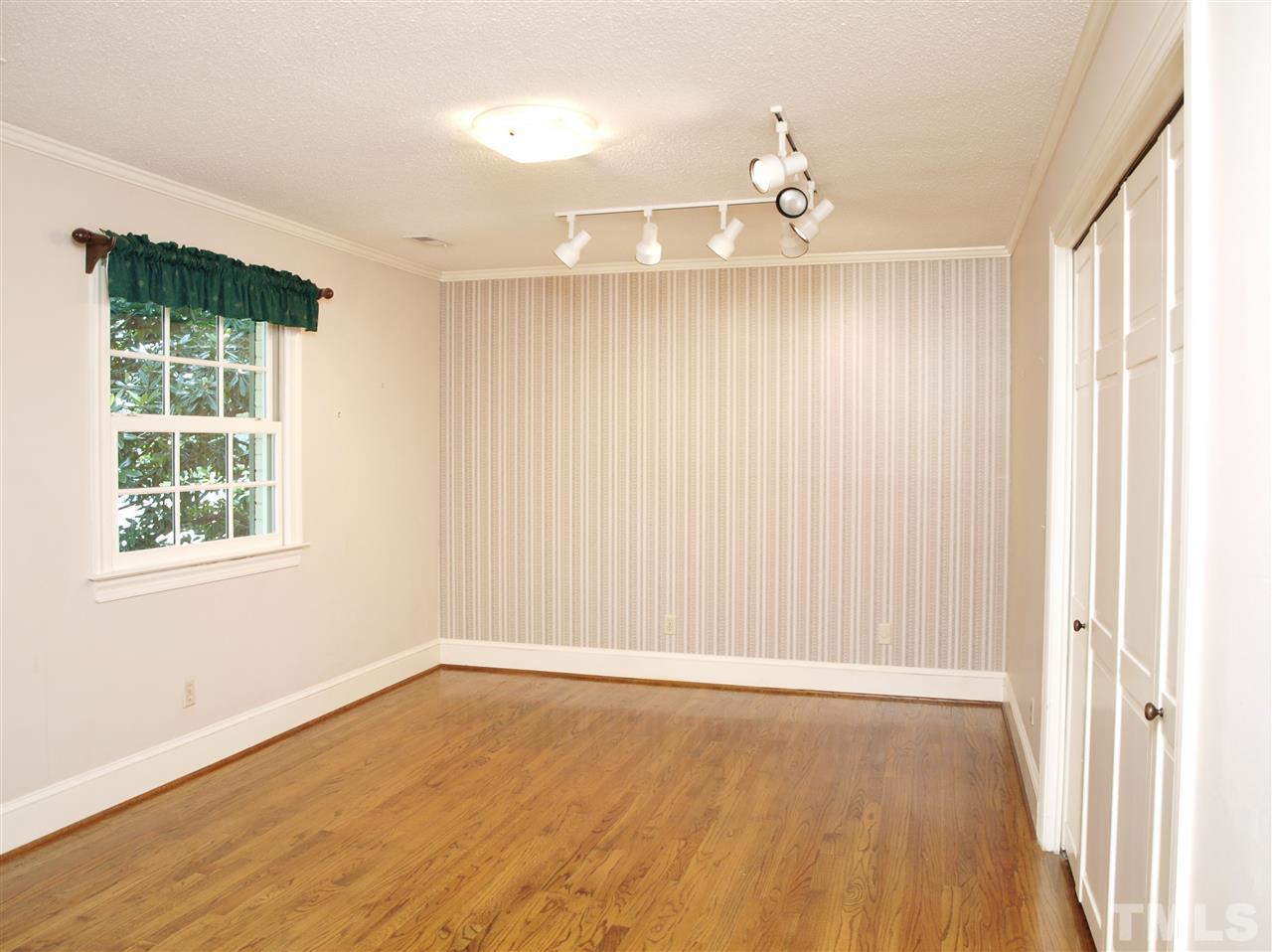 6705 Foxfire Place Raleigh, NC 27615 - Photo 22 of 30 a view of an empty room with wooden floor and a window