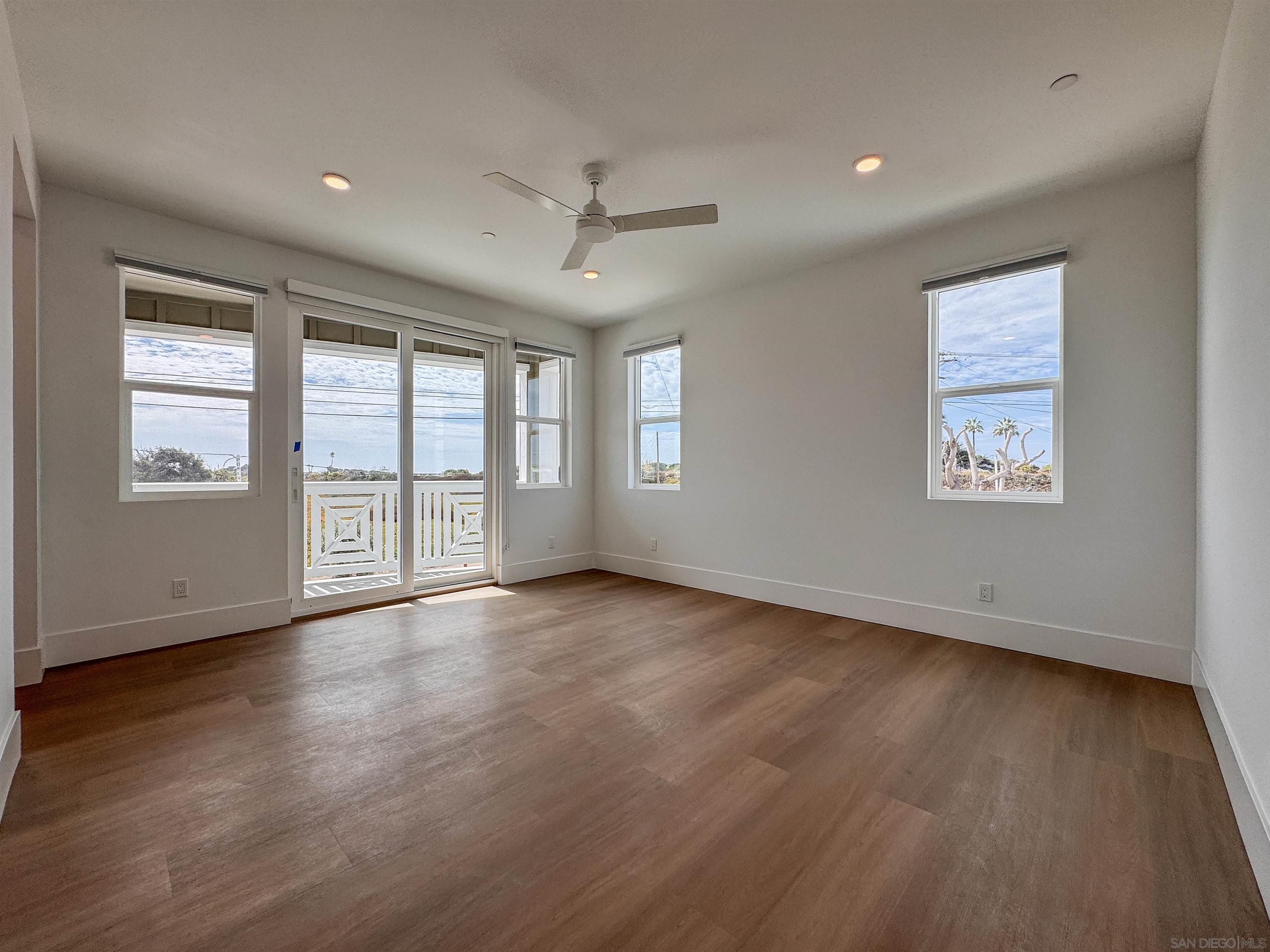 7290 Ponto Drive, Unit 7302 Carlsbad, CA 92011 - Photo 18 of 54 a view of an empty room with wooden floor and a window