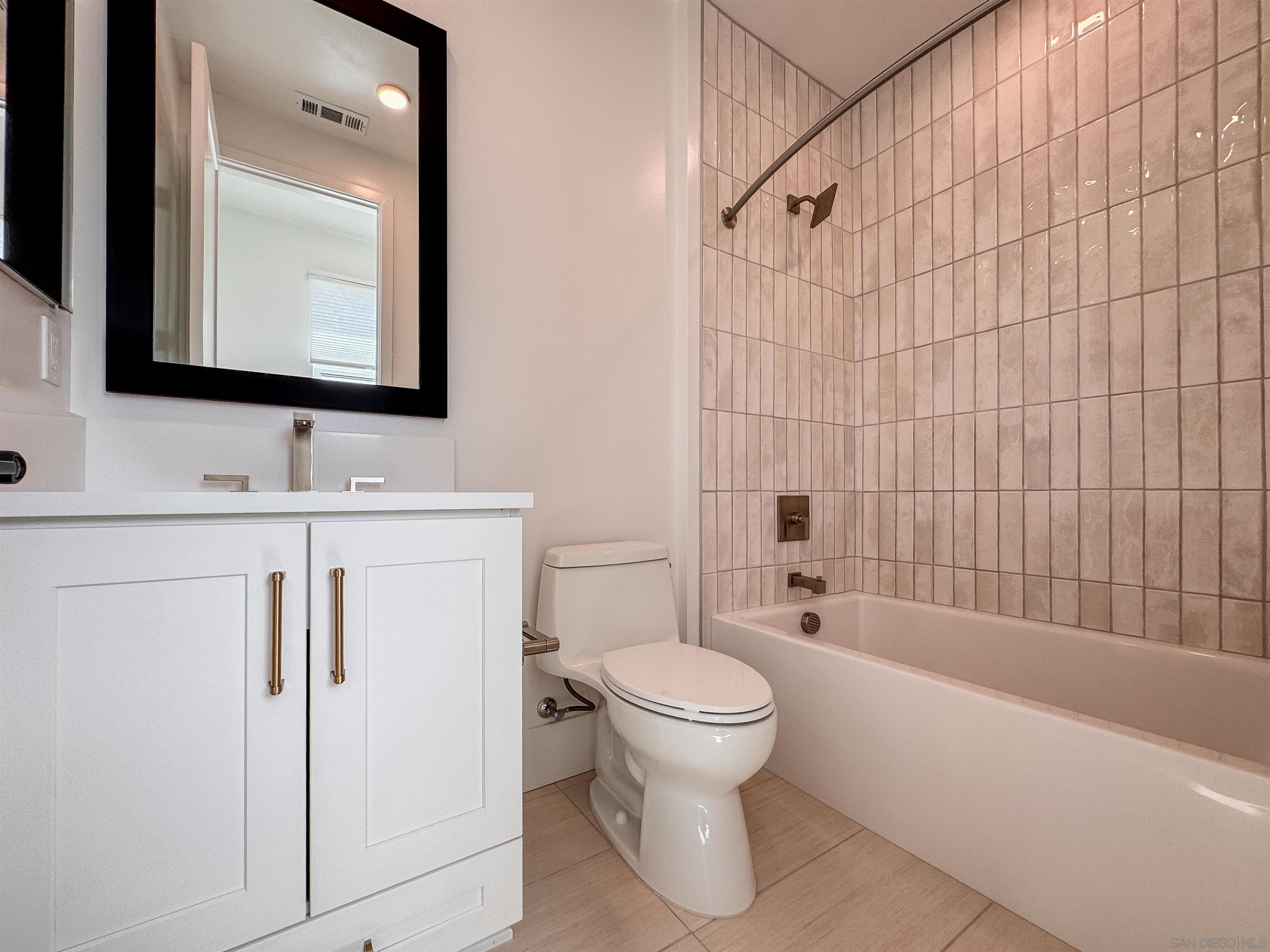 7290 Ponto Drive, Unit 7302 Carlsbad, CA 92011 - Photo 25 of 54 a bathroom with a toilet sink vanity tub and mirror