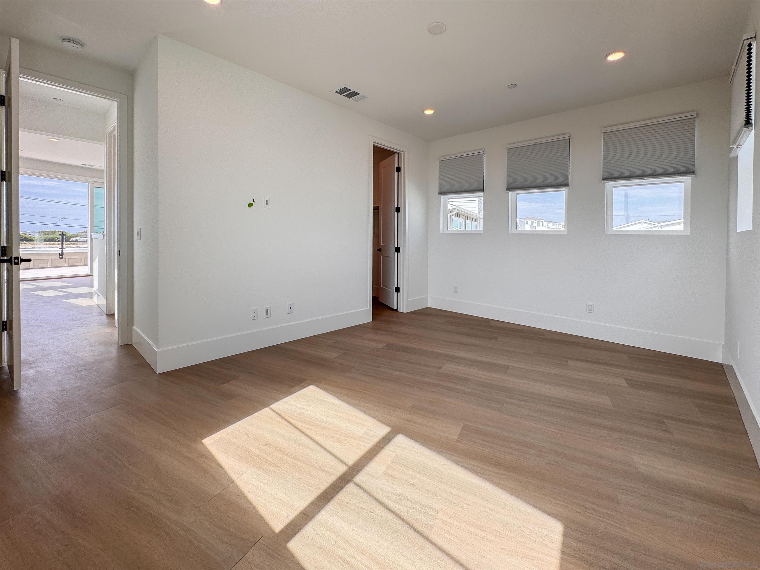 7290 Ponto Drive, Unit 7302 Carlsbad, CA 92011 - Photo 26 of 54 an empty room with wooden floor and windows