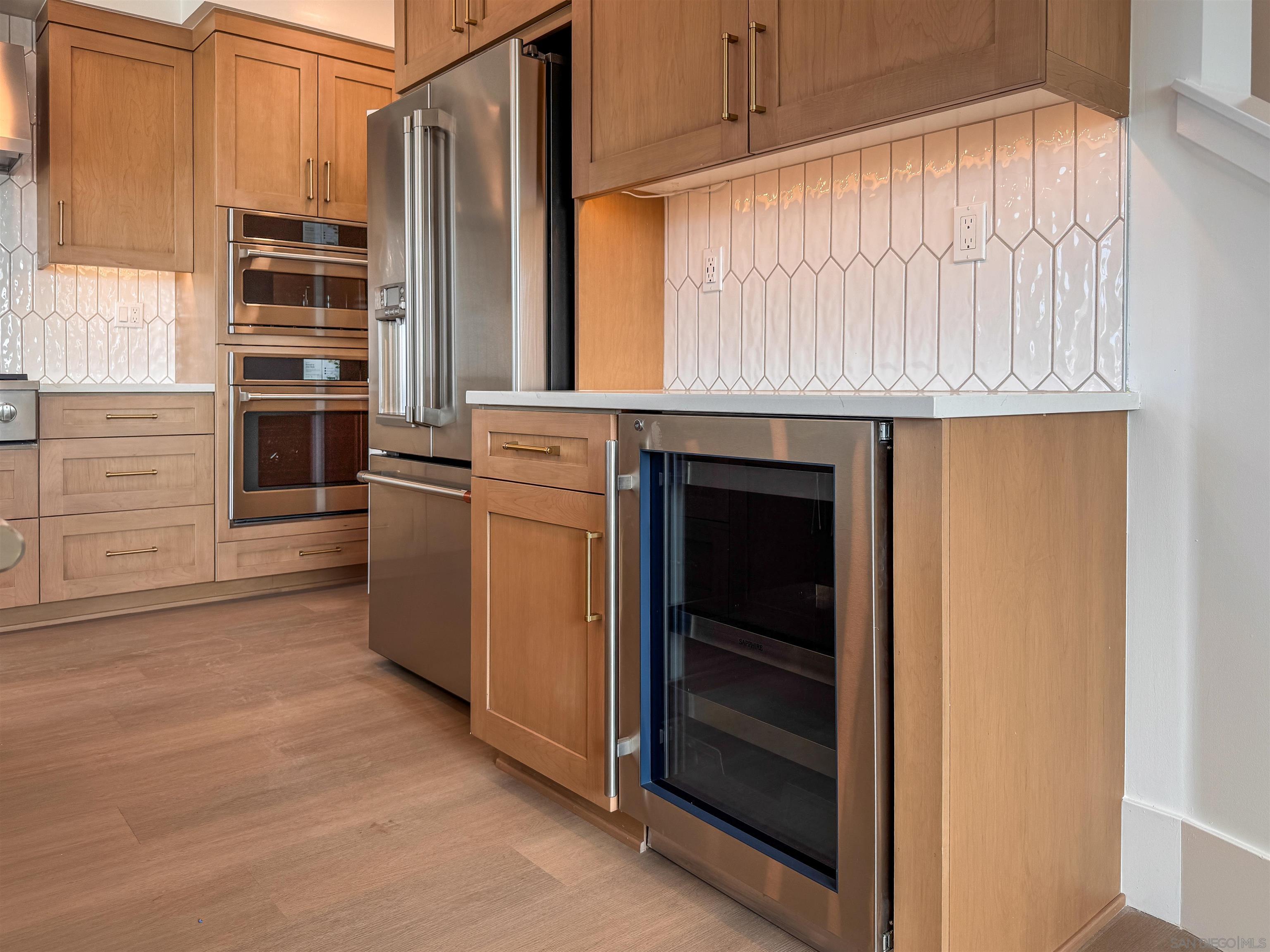 7290 Ponto Drive, Unit 7302 Carlsbad, CA 92011 - Photo 4 of 54 a kitchen with white cabinets and a refrigerator