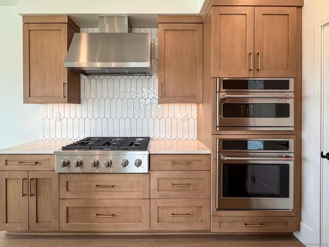 a kitchen with kitchen island a counter top space stainless steel appliances and wooden floor