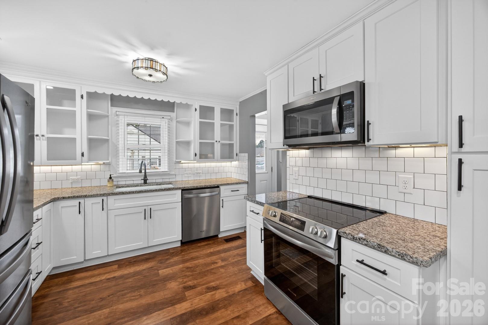 1016 Raney Street Salisbury, NC 28146 - Photo 10 of 45 a kitchen with stainless steel appliances granite countertop white cabinets a sink and a stove