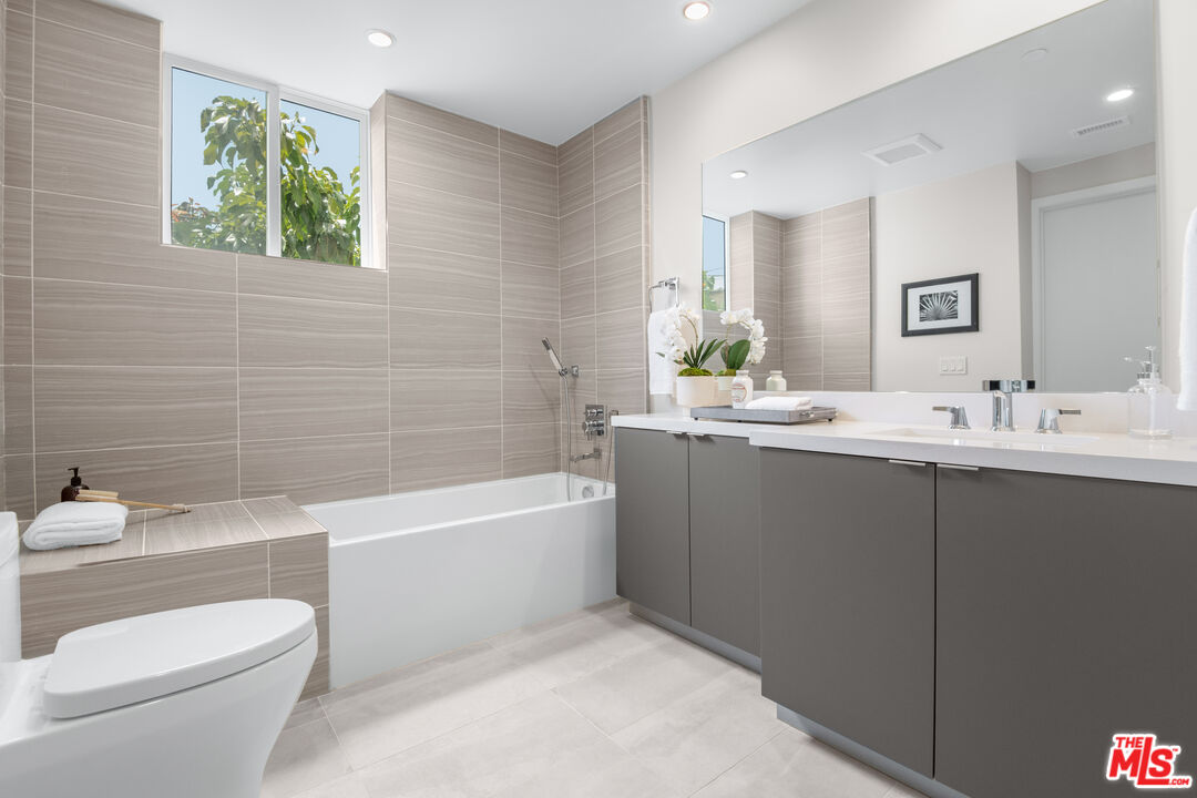 1226 South Bedford Street, Unit 504 Los Angeles, CA 90035 - Photo 11 of 16 a bathroom with a bathtub a sink a toilet and a mirror