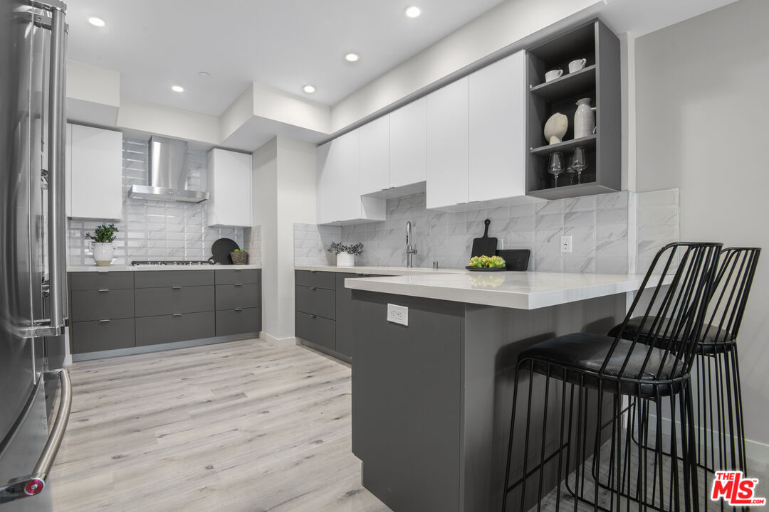 1226 South Bedford Street, Unit 504 Los Angeles, CA 90035 - Photo 5 of 16 a kitchen with stainless steel appliances granite countertop a sink stove and refrigerator