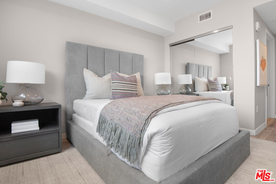 1226 South Bedford Street, Unit 504 Los Angeles, CA 90035 - Photo 6 of 16 a bedroom with a bed and a lamp