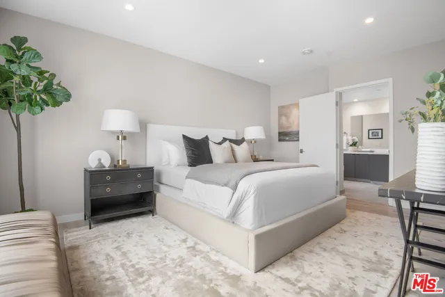 a bedroom with a bed and a potted plant