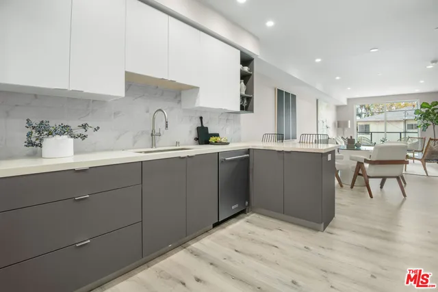 a kitchen with a sink a cabinets and chairs