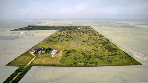 a view of a pathway both side of green field with lake in background