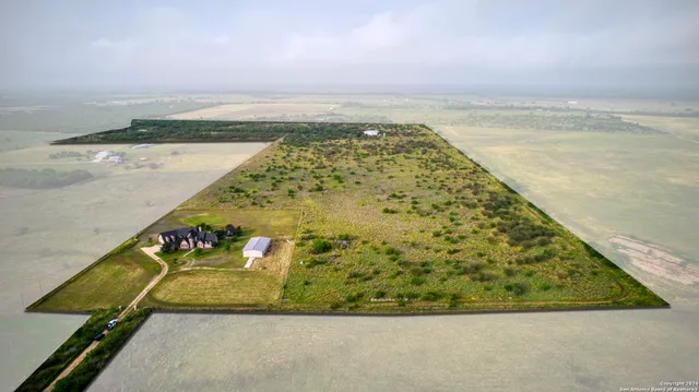 a view of a pathway both side of green field with lake in background