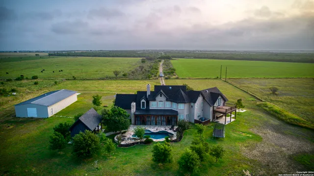 an aerial view of a house with a garden and lake view