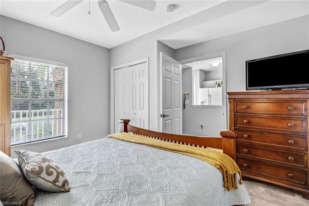 9175 Celeste Drive, Unit 2202 Naples, FL 34113 - Photo 13 of 27 a bedroom with a bed and flat screen tv