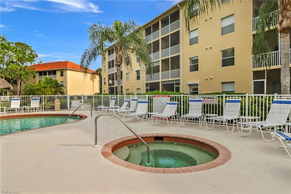 9175 Celeste Drive, Unit 2202 Naples, FL 34113 - Photo 24 of 27 a roof deck with table and chairs under an umbrella