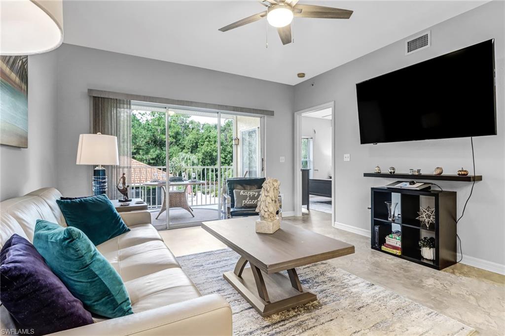 9175 Celeste Drive, Unit 2202 Naples, FL 34113 - Photo 10 of 27 a living room with furniture and a flat screen tv