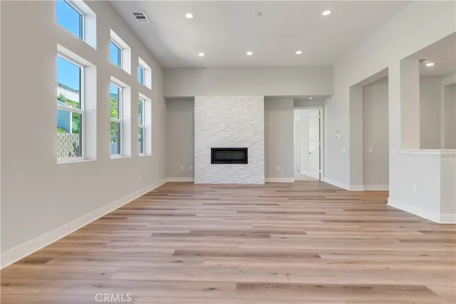 a view of empty room with wooden floor and entryway