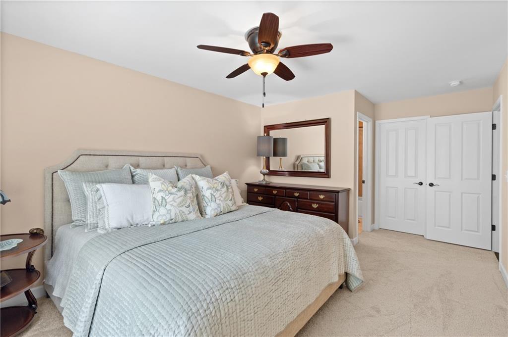 4469 Tacoma Trace Suwanee, GA 30024 - Photo 22 of 62 a bedroom with a bed and a ceiling fan