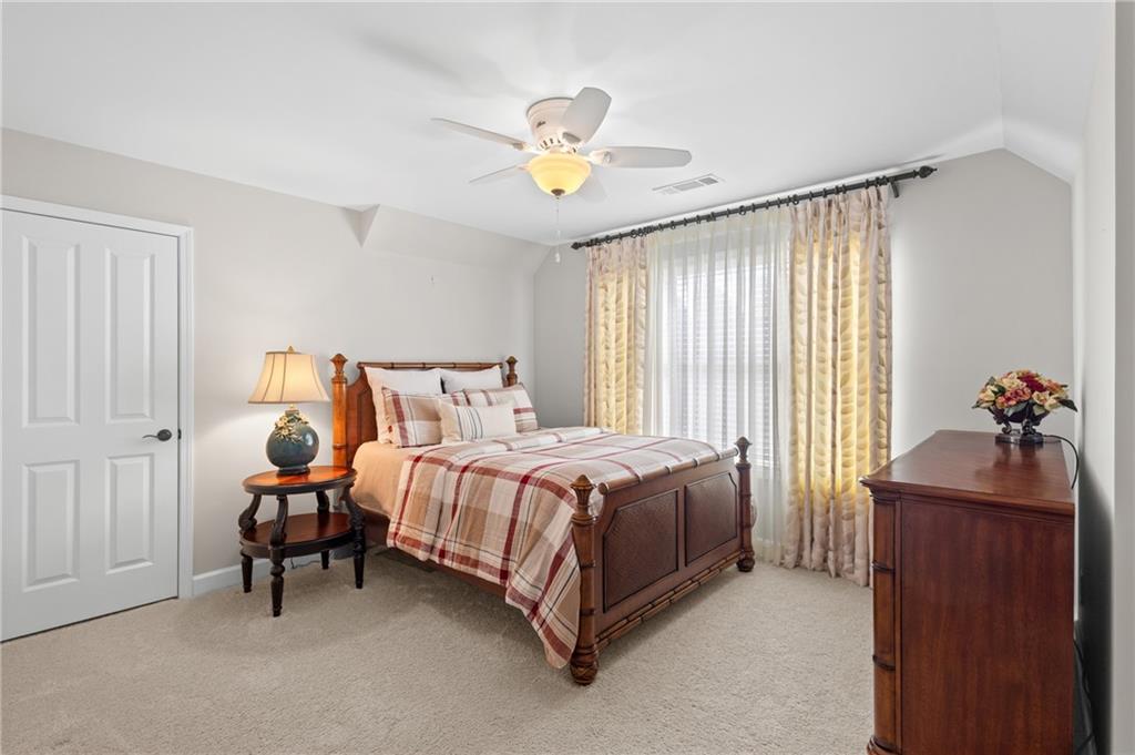 4469 Tacoma Trace Suwanee, GA 30024 - Photo 25 of 62 a bedroom with a bed and a chandelier