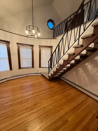 a view of an empty room with wooden floor