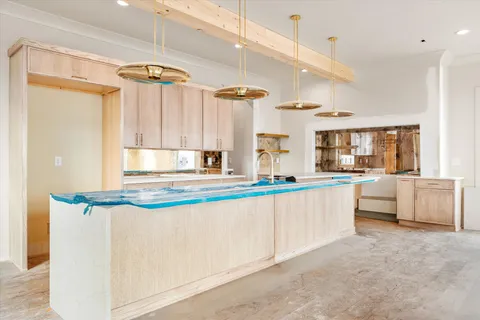 a view of a kitchen with kitchen island stainless steel appliances a sink and a wooden floor