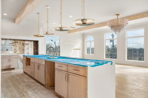 a large kitchen with kitchen island a large counter space wooden floor and stainless steel appliances