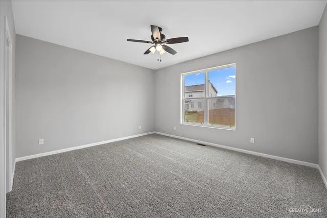 a view of a room with a ceiling fan and a ceiling fan